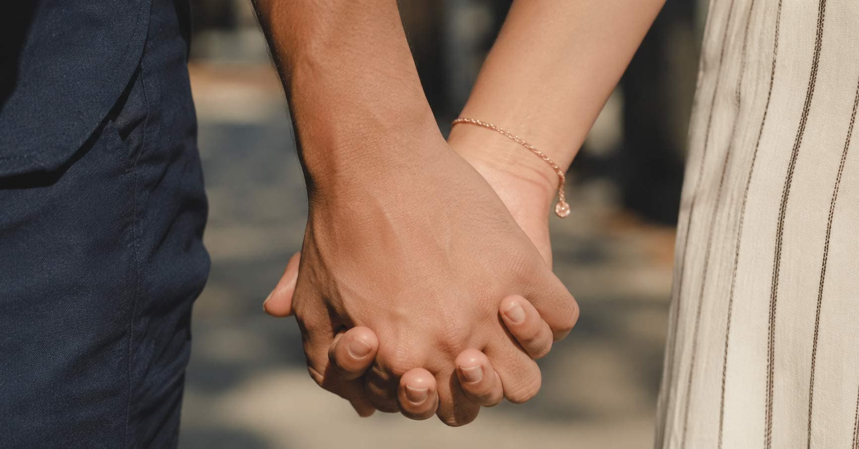 A couple sitting close together and gently holding hands